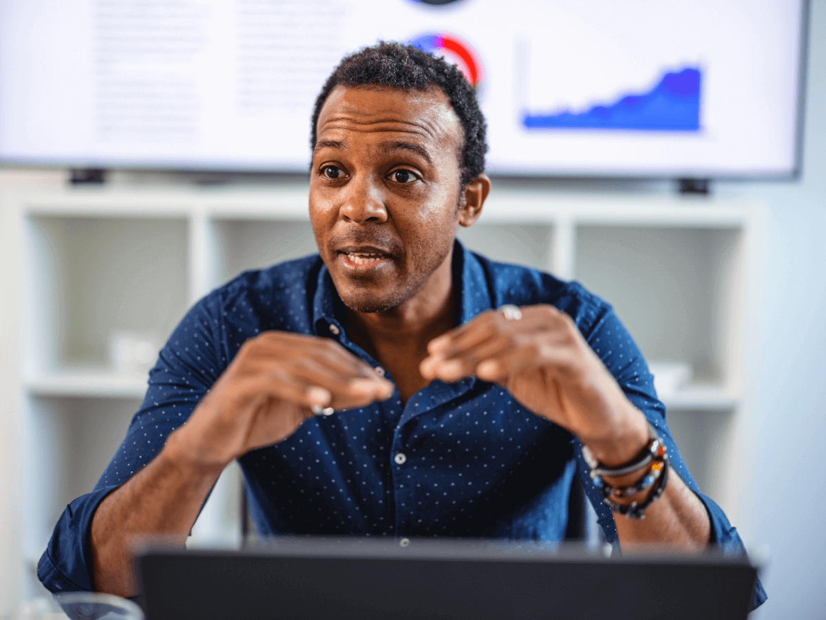 Expert in conversation with analytics screen behind